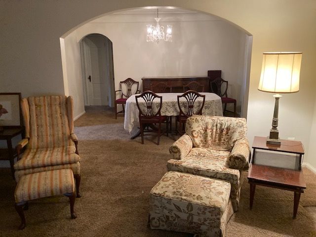 sitting room with a notable chandelier and carpet floors