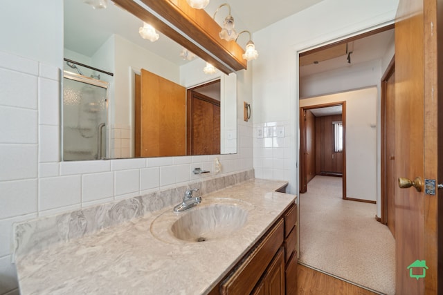 bathroom featuring hardwood / wood-style floors, vanity, tile walls, and a shower with shower door