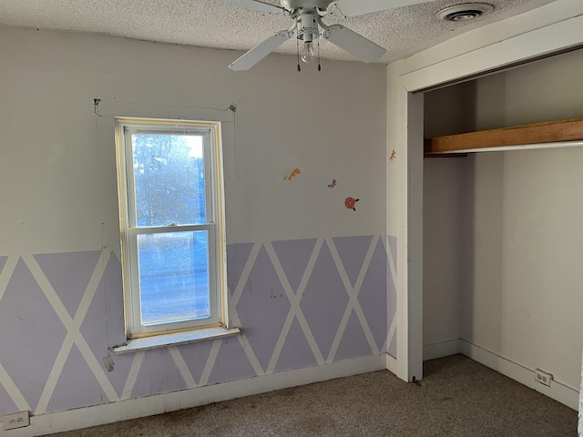 unfurnished bedroom with carpet floors, a textured ceiling, ceiling fan, and a closet