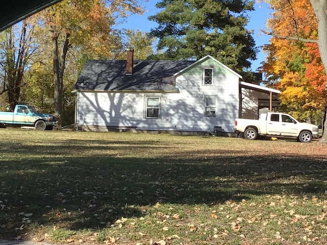 view of side of property featuring a carport and a lawn