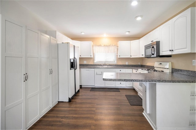 kitchen with white appliances, dark hardwood / wood-style floors, and white cabinetry