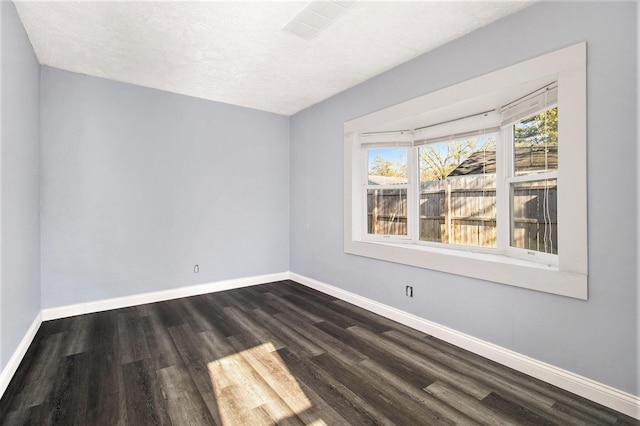 unfurnished room featuring dark hardwood / wood-style floors and a textured ceiling