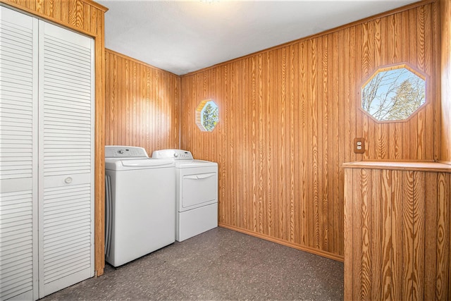 laundry room with separate washer and dryer and wooden walls