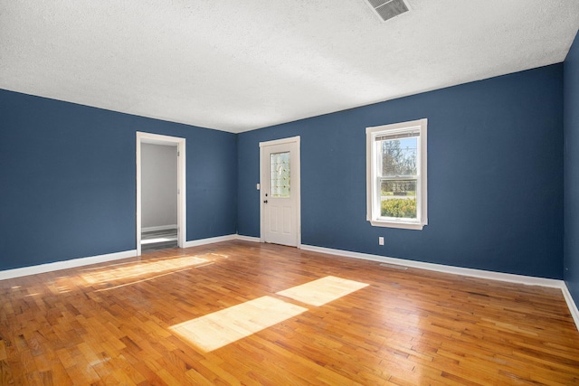 unfurnished room featuring wood-type flooring and a textured ceiling