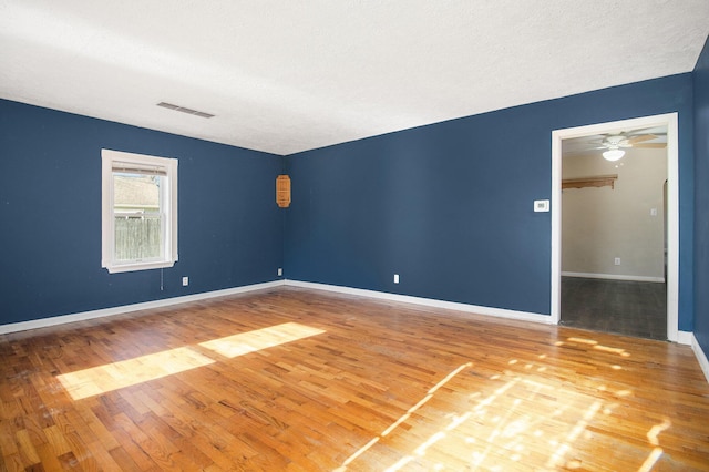 spare room with hardwood / wood-style floors, a textured ceiling, and ceiling fan