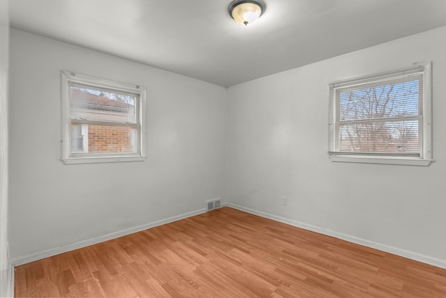 unfurnished room featuring light hardwood / wood-style floors and plenty of natural light