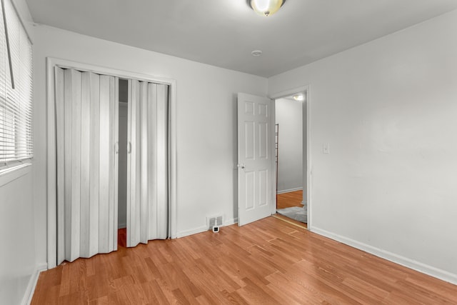 unfurnished bedroom featuring a closet and light hardwood / wood-style flooring