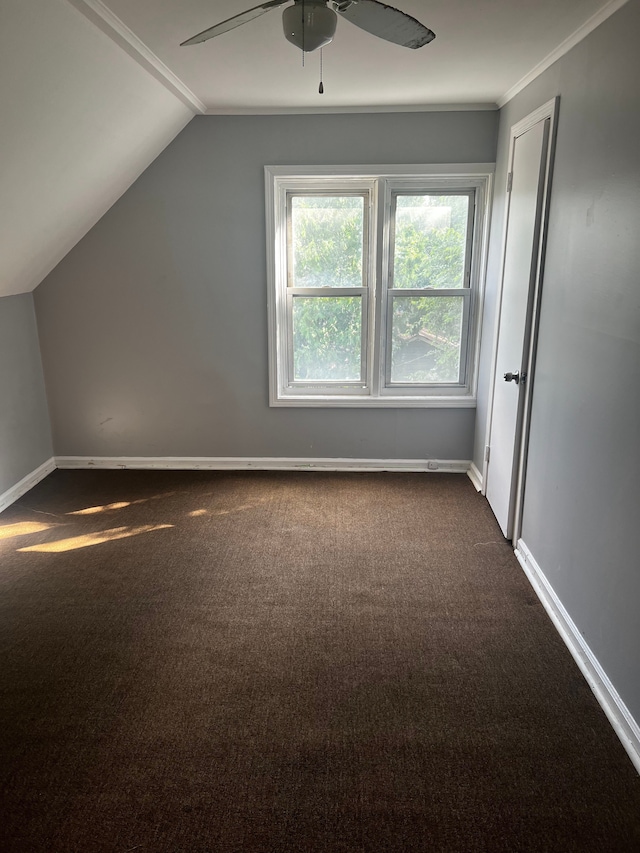 additional living space featuring dark colored carpet, vaulted ceiling, and ceiling fan