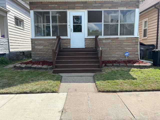 entrance to property with a lawn