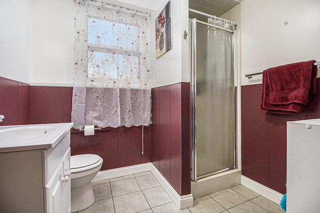 bathroom with tile patterned flooring, vanity, a shower with door, and toilet