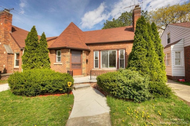 13966 Warwick St, Detroit, MI 48223 - view of front of property with brick siding, a chimney, and a front yard