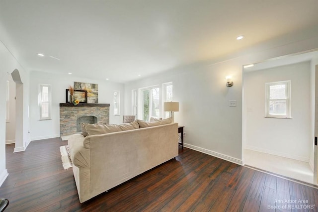 living room featuring a fireplace and dark wood-type flooring