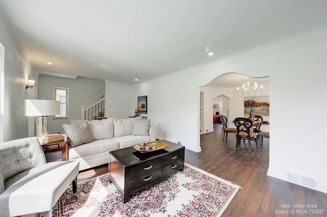 living room with dark hardwood / wood-style floors and an inviting chandelier