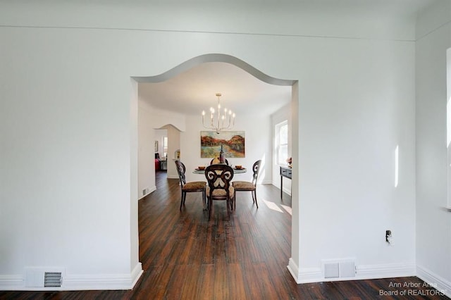 13966 Warwick St, Detroit, MI 48223 - dining space with a chandelier, dark wood-style floors, and arched walkways