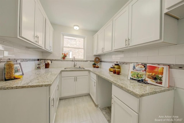 13966 Warwick St, Detroit, MI 48223 - kitchen with backsplash, white cabinetry, and light stone counters
