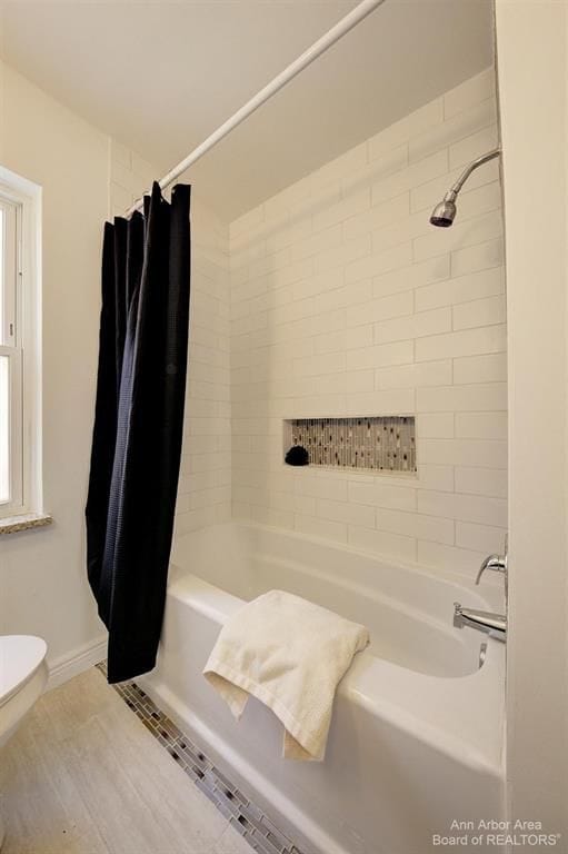 bathroom featuring shower / bath combo and toilet