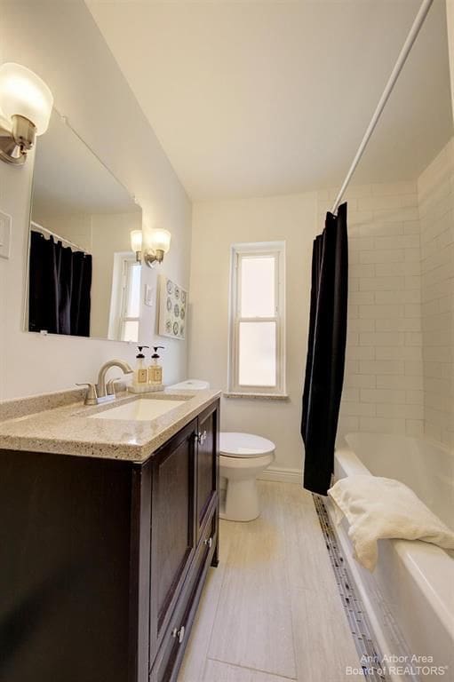 full bathroom featuring vanity, toilet, shower / bath combo, and an inviting chandelier