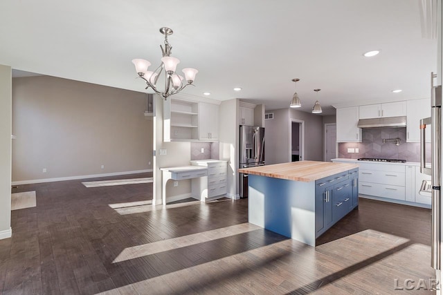 kitchen featuring white cabinetry, butcher block counters, blue cabinetry, and a center island