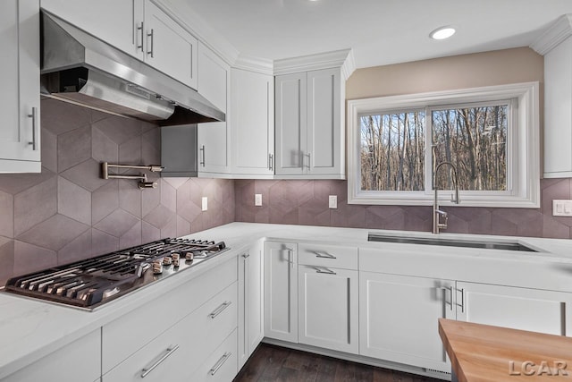 kitchen featuring white cabinets, stainless steel gas cooktop, sink, and light stone counters