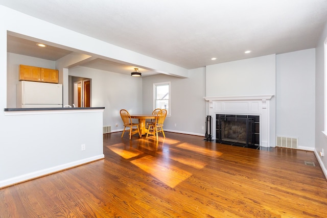 unfurnished living room with a tile fireplace and dark hardwood / wood-style floors