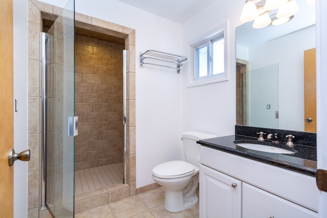 bathroom with tile patterned flooring, vanity, toilet, and a shower with door