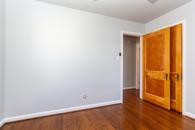 unfurnished room with dark hardwood / wood-style flooring