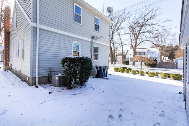 view of snow covered exterior with central AC