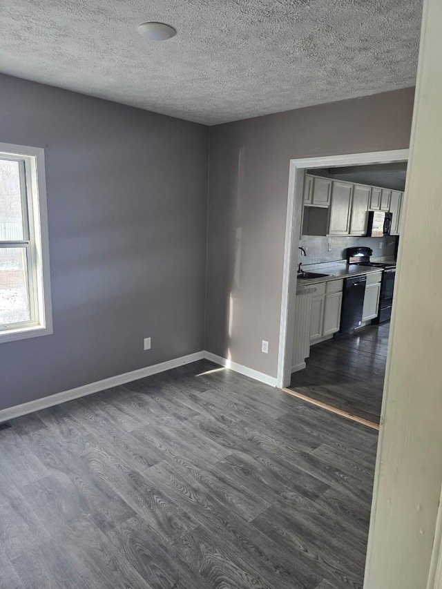 unfurnished living room featuring dark wood-type flooring and a textured ceiling