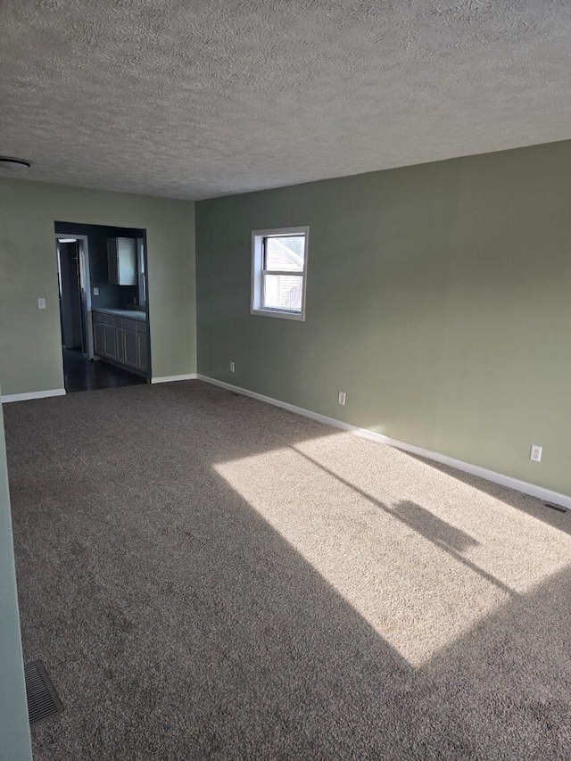 carpeted spare room featuring a textured ceiling