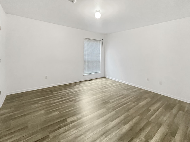 unfurnished room with dark hardwood / wood-style flooring