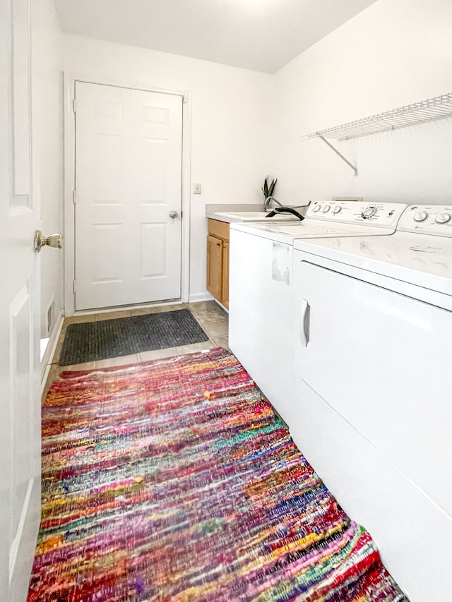 laundry area featuring independent washer and dryer and cabinets