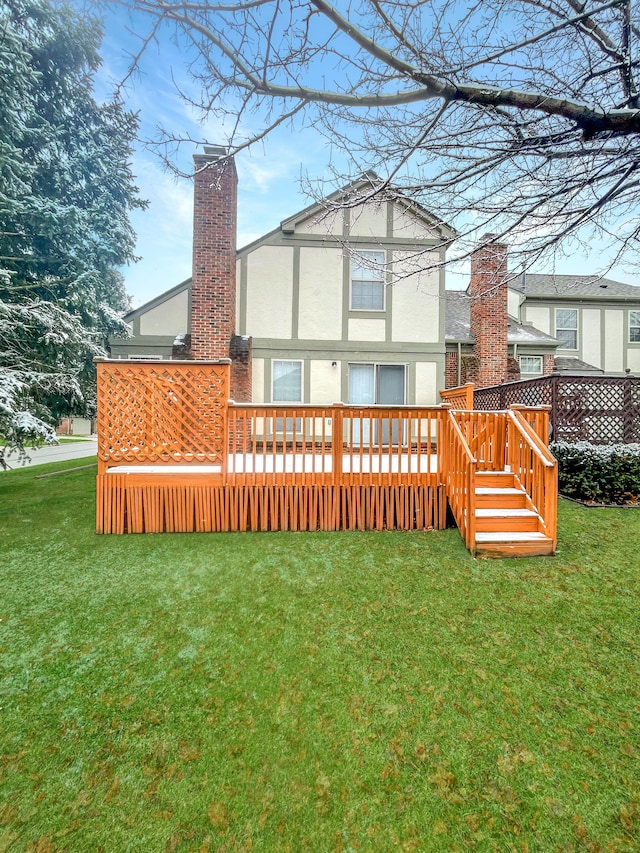 back of house featuring a wooden deck and a yard