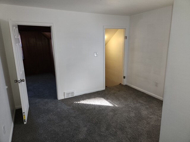 empty room with dark colored carpet