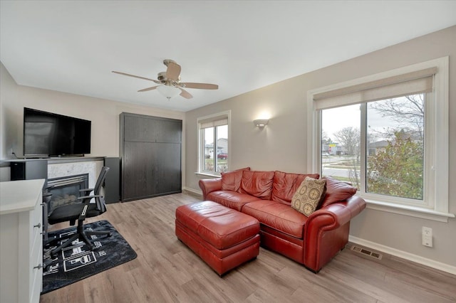 living room with light hardwood / wood-style flooring and ceiling fan