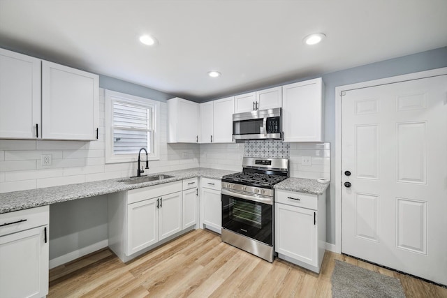 kitchen featuring white cabinets, light hardwood / wood-style floors, sink, and stainless steel appliances