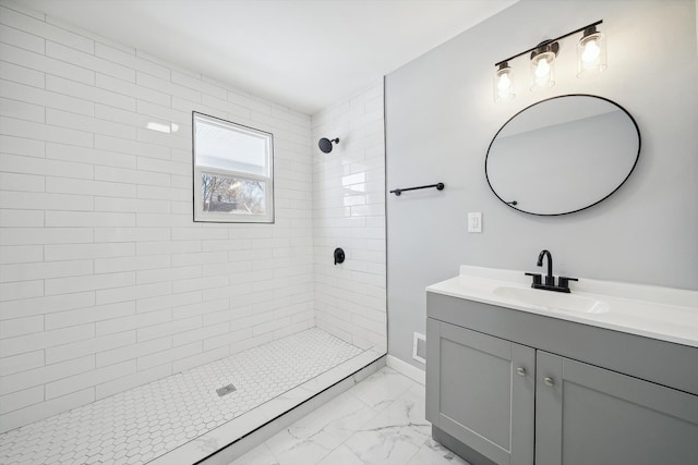 bathroom with vanity and a tile shower