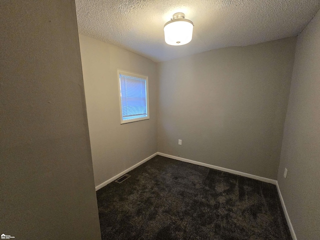 carpeted spare room featuring a textured ceiling