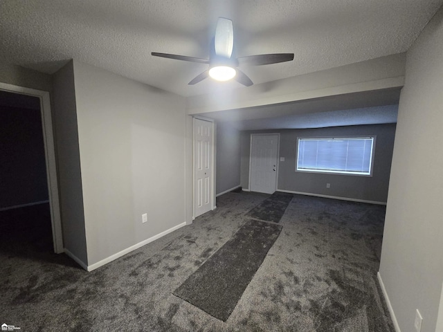 carpeted spare room featuring a textured ceiling and ceiling fan