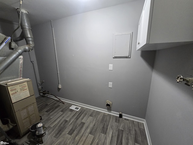 laundry area with dark hardwood / wood-style floors and cabinets