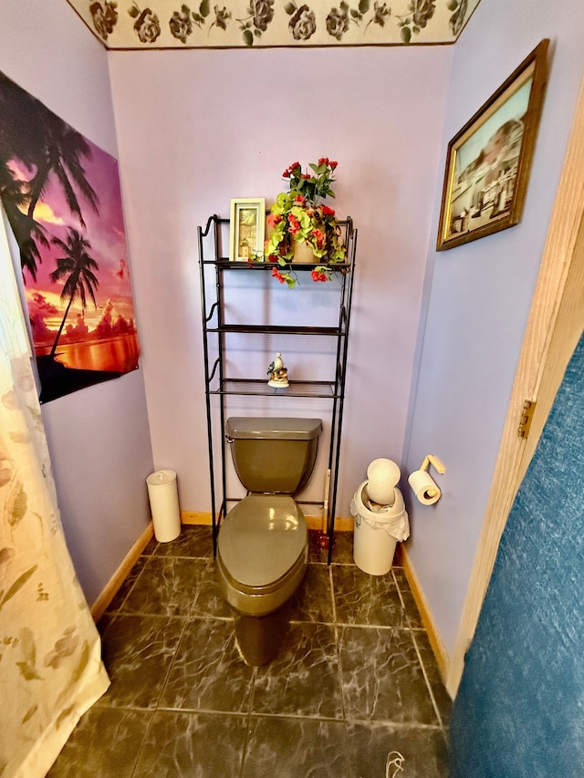 interior space with toilet, marble finish floor, and baseboards