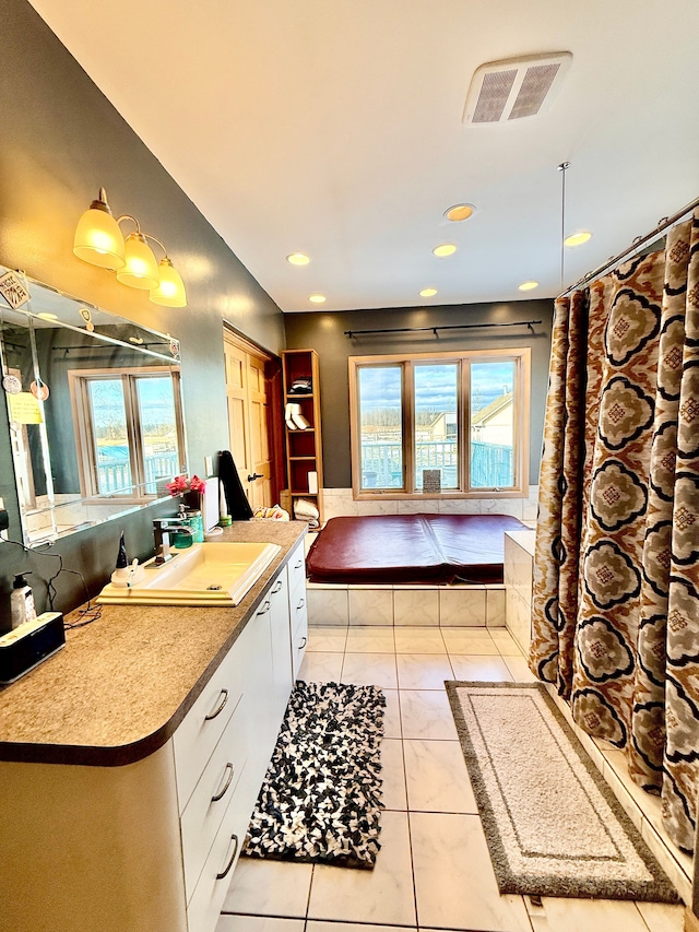 bathroom with a wealth of natural light, visible vents, vanity, and tile patterned floors