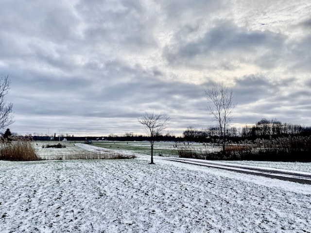 snowy yard with a rural view