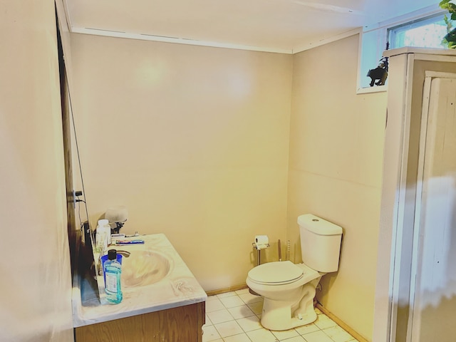 bathroom with tile patterned flooring, baseboards, vanity, and toilet