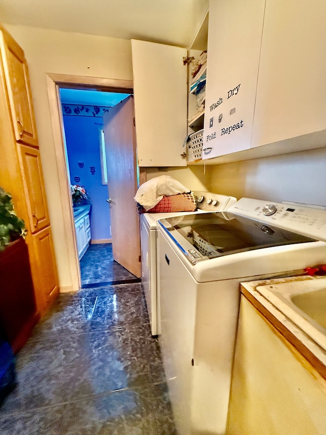 laundry area featuring washer and clothes dryer and cabinet space