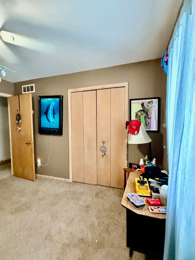 carpeted bedroom featuring ceiling fan, a closet, visible vents, and baseboards