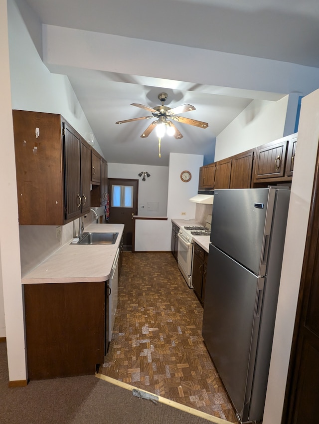 kitchen featuring dark parquet floors, stainless steel appliances, ceiling fan, sink, and lofted ceiling