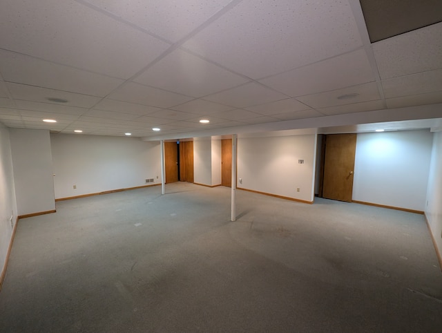 basement featuring light carpet and a paneled ceiling