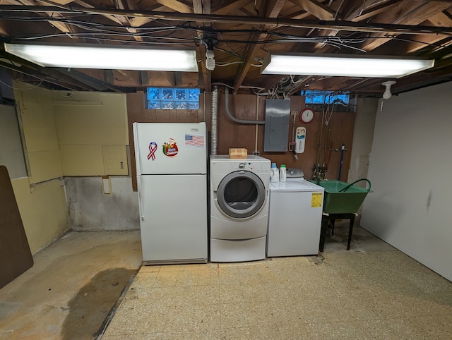 clothes washing area with independent washer and dryer, electric panel, and sink