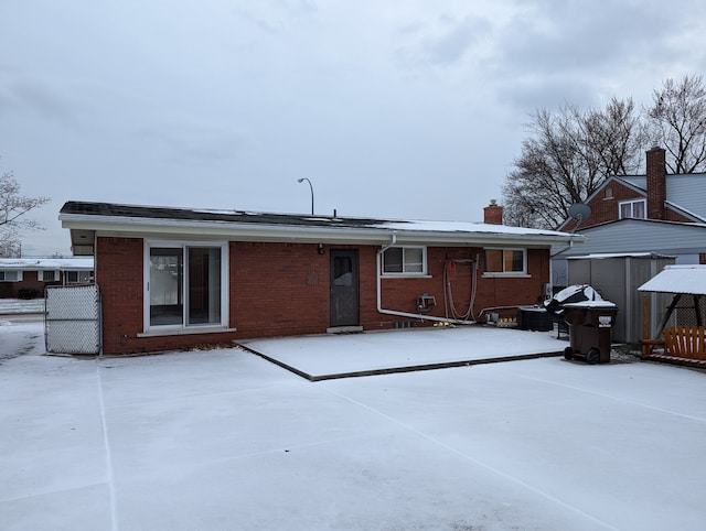 view of snow covered rear of property