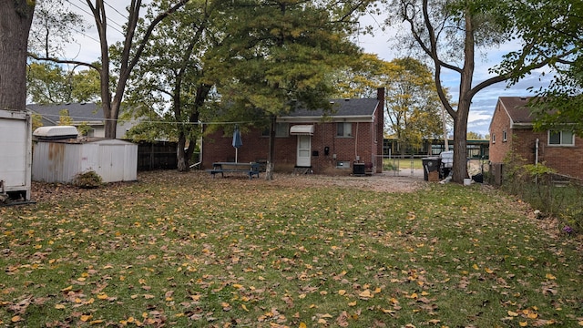 view of yard with an outbuilding, central AC, a storage unit, and a fenced backyard